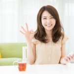 部屋でスマートフォンを見る女性